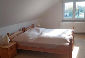 a bedroom with a wooden bed and a window at Ferienhaeuser auf dem Land Hoffelde SEE 8070 in Hoffelde