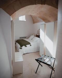 1 dormitorio blanco con 1 cama y 1 silla en Sant'Angelo, Matera, en Matera