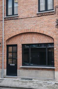 un bâtiment en briques avec une arche au-dessus d'une porte dans l'établissement Vakantiewoning number 44, à Ypres