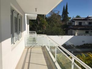 einen Balkon eines Hauses mit weißem Geländer in der Unterkunft Beach Town Condo 2 rooms in Sosúa