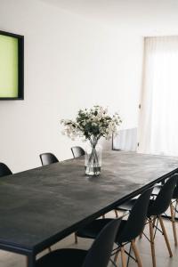 a black table with chairs and a vase of flowers at Vakantiewoning number 44 in Ieper