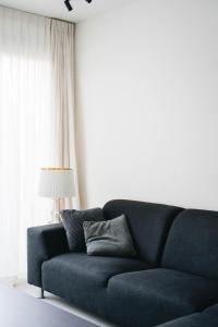 a blue couch in a living room with a lamp at Vakantiewoning number 44 in Ypres