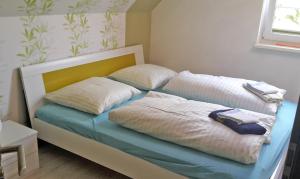 1 cama con 2 almohadas en una habitación en Countryside-Lovers - Ganzes Haus 100m² für euch allein mit Garten, en Halsbrücke