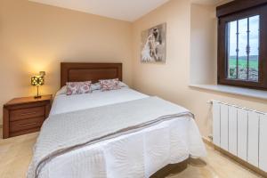 a bedroom with a white bed and a window at La Casonia in Anero
