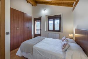 Schlafzimmer mit einem weißen Bett und Holzschränken in der Unterkunft La Casonia in Anero