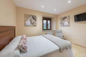a bedroom with a bed and two pictures on the wall at La Casonia in Anero +8 photos
