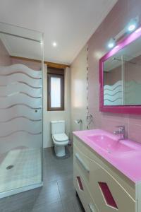 ein Badezimmer mit einem rosa Waschbecken und einem WC in der Unterkunft La Casonia in Anero