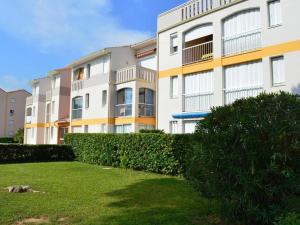 um grande edifício de apartamentos com uma sebe em frente em Appartement Argelès-sur-Mer, 1 pièce, 3 personnes - FR-1-225-634 em Argelès-sur-Mer