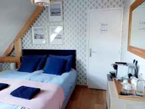 Un dormitorio con una cama con almohadas azules. en Chambres d'hôtes chez l'habitant - Bed& Breakfast homestay, en Huisnes-sur-Mer