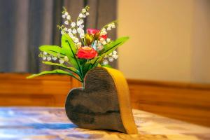 a heart shaped vase with a bouquet of flowers at Gästehaus Wolf in Pfronten