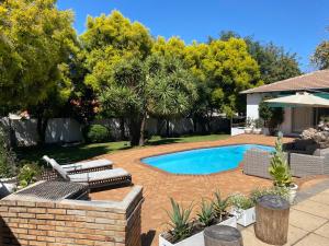 Johannesburg的住宿－The African Element，后院设有游泳池、椅子和树木