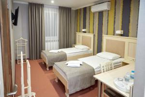 Cette chambre comprend 2 lits et un lavabo. dans l'établissement Hotel Korona, à Mostiska