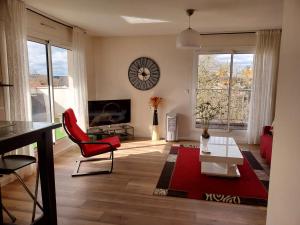 a living room with a red chair and a table at Les Burgondes in Dijon