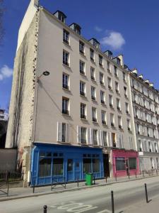 duży biały budynek po stronie ulicy w obiekcie PARIS 14e centre avec cuisine w Paryżu