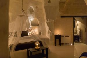 1 dormitorio con 1 cama con lámpara de araña en Sant'Angelo Luxury Resort, en Matera