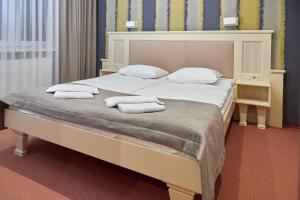 una camera da letto con un grande letto con asciugamani di Hotel Korona a Mostiska