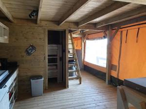 an inside view of a cabin with a kitchen and a window at Safaritent Betuwe Lodge in Kesteren