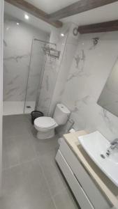 ein weißes Bad mit einem WC und einem Waschbecken in der Unterkunft vivienda turística los Robles in Tudela