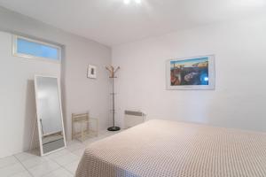 une chambre blanche avec un lit et un tableau sur le mur dans l'établissement Overlooking Sea Maisonette With BBQ For 7 Ppl, à Kóstos