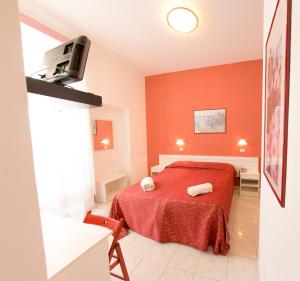 a red bedroom with a bed with a red blanket at Hotel Regina in Lido di Camaiore