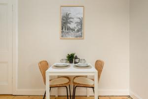 einem weißen Tisch mit zwei Stühlen und einem Bild an der Wand in der Unterkunft The Raeburn Residence - Stockbridge in Edinburgh