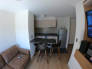 a small kitchen and living room with a table and a couch at Apartment With Pool Access in Temuco