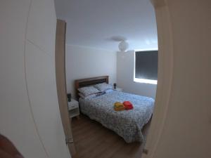 a small bedroom with a bed and a window at Apartment With Pool Access in Temuco