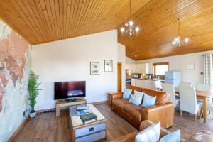 a living room with a couch and a table at Douglas Fir Lodge with Hot tub in Cupar
