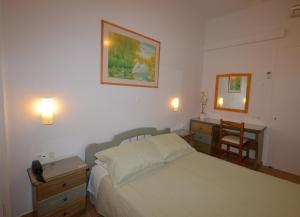 1 dormitorio con cama, escritorio y espejo en Konstantza Studios and Apartments, en Ermoupoli