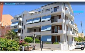 a white building with windows on the side of it at Alkira Lodge in Alghero