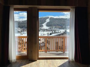 a window with a view of a snow covered mountain at Hotel Piccolo Tibet in Livigno