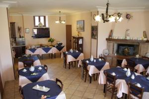 a dining room with tables and chairs and a fireplace at Agriturismo La Fattoria in Norcia
