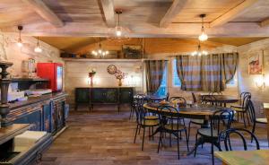 a dining room with tables and chairs and a kitchen at Cit'Hotel Le Montreal in Chalons en Champagne