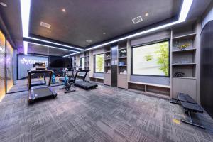 a gym with cardio equipment and a large screen at Atour Hotel Changsha Dongtang in Changsha