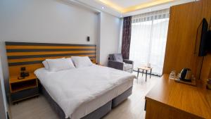 um quarto de hotel com uma cama grande e uma cadeira em Cabana Boutique Hotel & Cafe em Milas