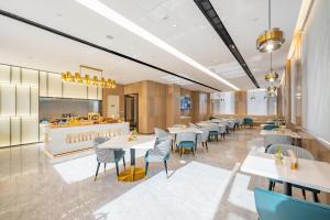 a restaurant with tables and chairs and a kitchen at Atour Hotel Hefei Binhu International Convention and Exhibition Center in Hefei