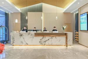 a group of people sitting at a table in a lobby at Atour Hotel Beijing Joy City Chaoyang Road in Beijing
