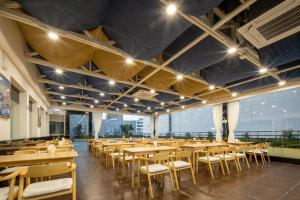 a dining room with wooden tables and chairs at Atour X Hotel Shenzhen Airport Bao'an Yitian Plaza in Bao'an
