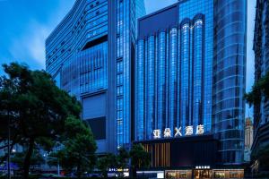 深セン市にあるAtour X Hotel Shenzhen Luohu Dongmen Pedestrian Streetの標識が書かれた高いガラス張り