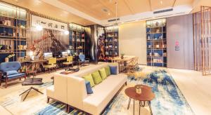 a living room with a couch and chairs and tables at Atour Hotel North High Speed Railway Station Xi'an in Xi'an