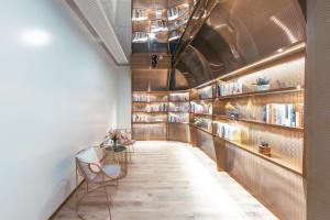 a hallway with bookshelves and chairs in a room at Atour Light Hotel Shanghai East Nanjing Road in Shanghai