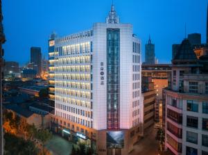 Atour S Hotel Tianjin Binjiang Road Hanglung Plaza في تيانجين: تقديم المبنى المكتبي في الليل