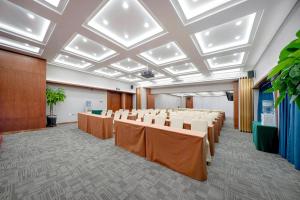 uma sala de conferências com fileiras de mesas e cadeiras em Atour X Hotel Harbin West Railway Station em Harbin