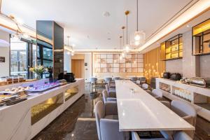 a restaurant with a long table and chairs at Atour Hotel Xiamen Lianban Mingfa Plaza in Xiamen