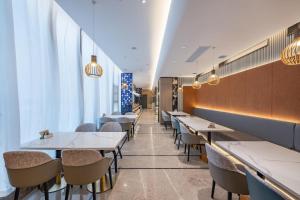 a row of tables and chairs in a restaurant at Atour Hotel Chengdu Taikoo Li Chunxi Road Pedestrian in Chengdu