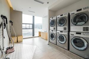 a laundry room with four washers and dryers at Atour Hotel Chengdu Taikoo Li Future Center in Chengdu