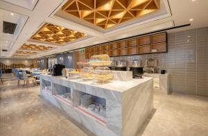 a restaurant with a counter with food on it at Atour Hotel Changsha International Covention Centre South Railway Station in Changsha