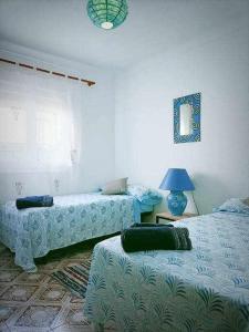 a room with two beds and a lamp in it at Casa de pueblo in Carboneras