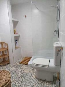 a white bathroom with a toilet and a shower at Casa de pueblo in Carboneras