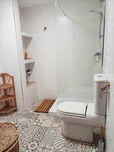 a white bathroom with a toilet and a shower at Casa de pueblo in Carboneras